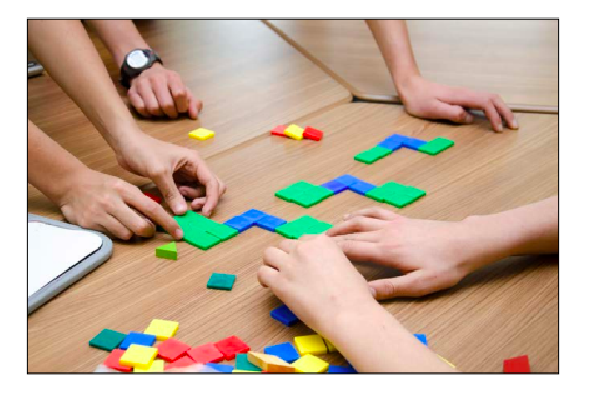 Image de mains utilisant des matériaux de manipulation « des mosaïques géométriques », de différentes couleurs, quadrillés pour former une suite croissante.