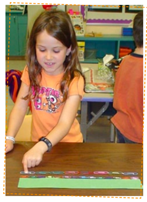 A student measures the length of a box using paperclips. The first line is made up of 14 small paperclips. The second line is made up of 8 large paperclips